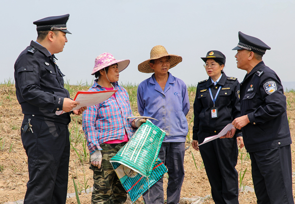 聯(lián)合執(zhí)法人員在田間地頭向種植戶講解宣傳