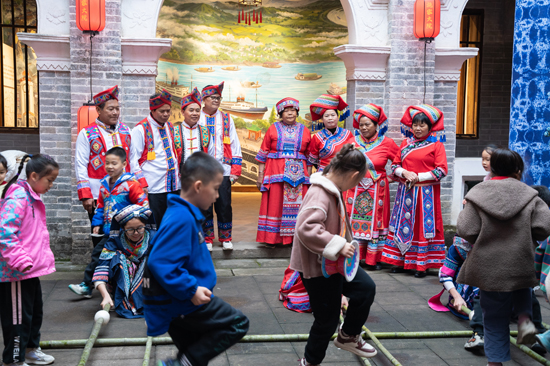 游客在施家大院內(nèi)體驗(yàn)跳竹竿。