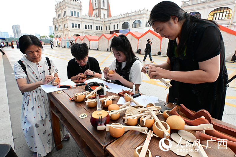 市民們在非遺展示體驗(yàn)坊體驗(yàn)制作天琴。人民網(wǎng) 雷琦竣攝