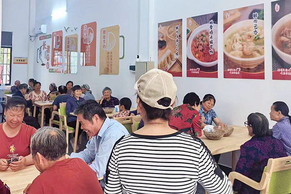 老人在社區(qū)愛心食堂體驗(yàn)餐食。覃友麗攝