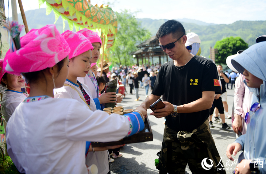 村民向游客敬上迎賓酒。