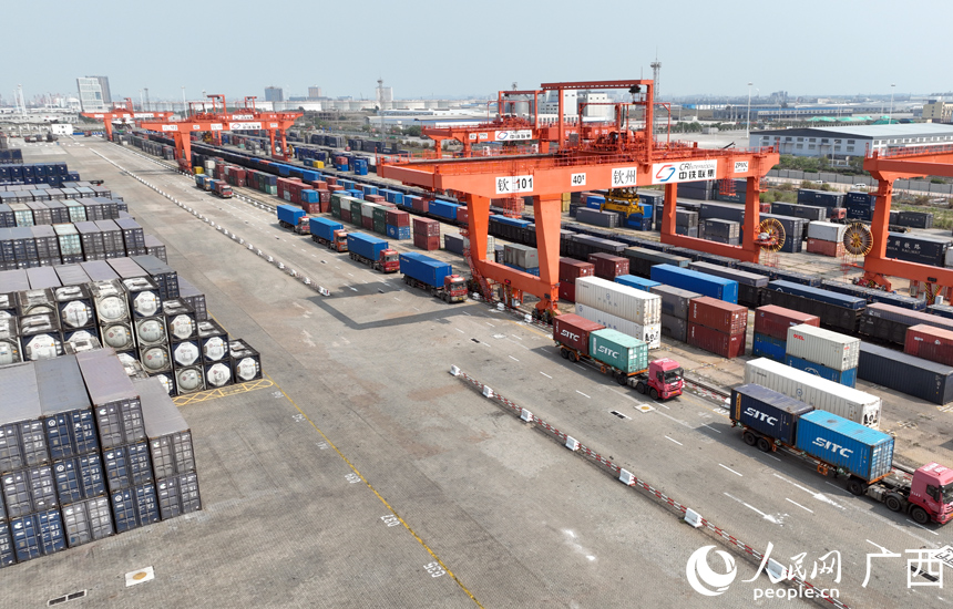 自動(dòng)化龍門吊正在裝卸汽運(yùn)集裝箱貨物。