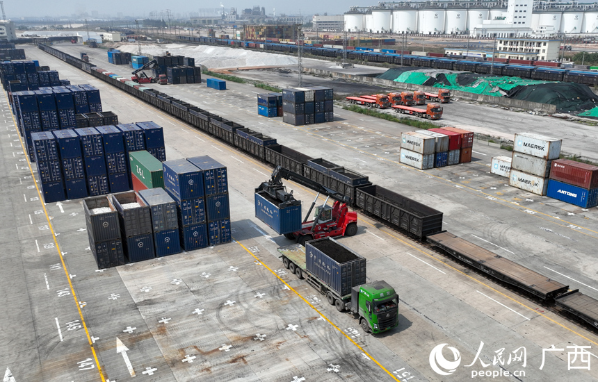 一臺正面吊正在貨場內(nèi)吊裝集裝箱貨物。