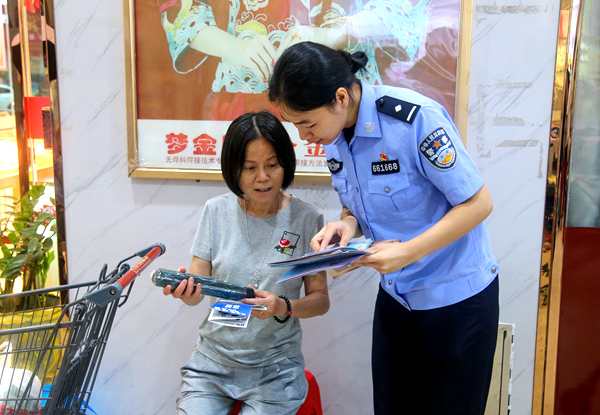 民警向群眾發(fā)放宣傳手冊。