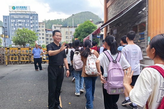 深圳市光明區(qū)教育幫扶團隊領隊、田林縣初級中學校長黃慶通目送孩子們放學。田林縣初級中學供圖