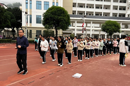 深圳市光明區(qū)教育幫扶團隊領隊、田林縣初級中學校長黃慶通帶領學生跑操。田林縣初級中學供圖