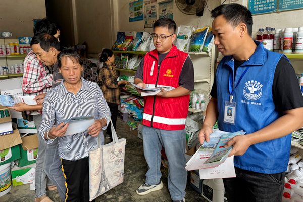 工作人員向群眾發(fā)放法治宣傳冊。