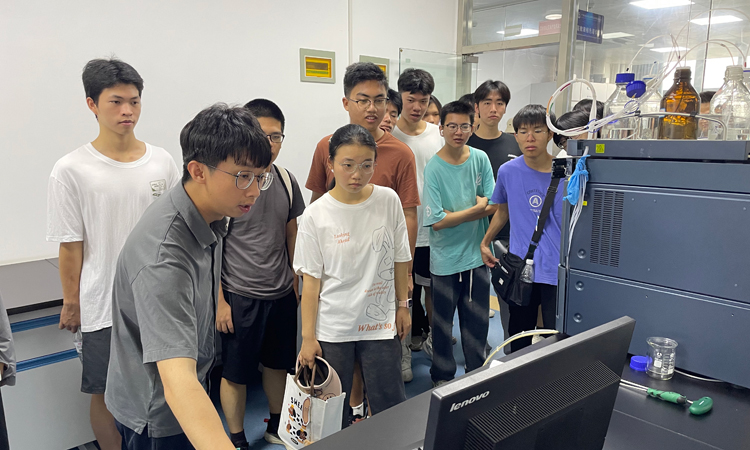 來賓監(jiān)測中心技術(shù)人員(左一)向參觀學(xué)習(xí)的大學(xué)生介紹大型儀器的使用要點