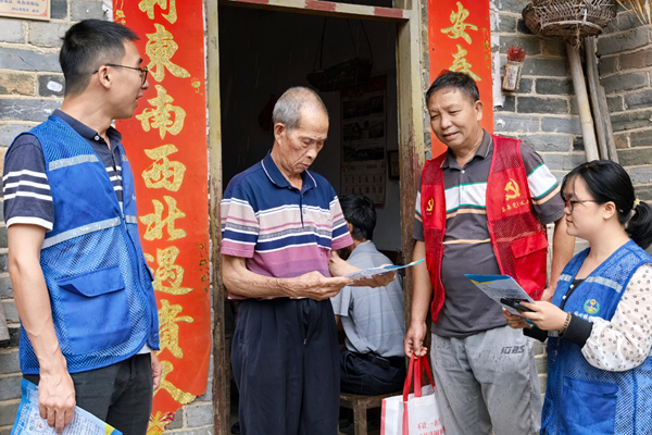 黨員志愿者和網(wǎng)格員向群眾宣傳防汛知識(shí)，提醒群眾做好防護(hù)。程豪輝攝