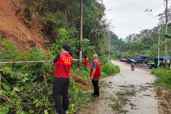 黨員志愿者在對塌方路段拉警戒線，提醒過路群眾。周清連攝