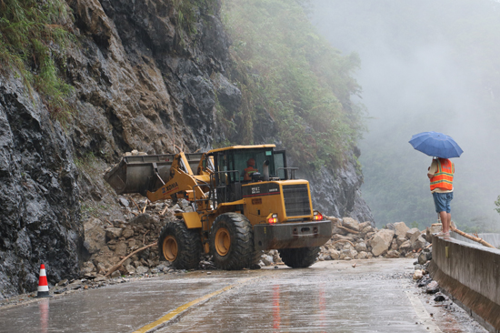 凌云公路養(yǎng)護中心應(yīng)急組利用鏟車清理路面落石。黎海青攝
