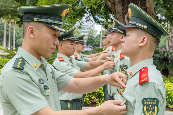 老黨員為新黨員佩戴黨徽。