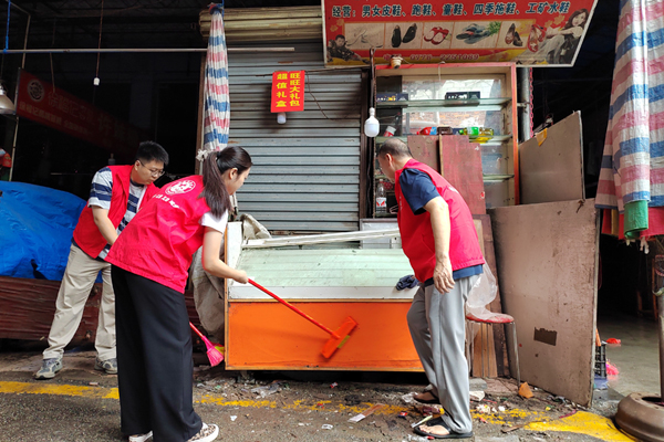 黨員同志幫助受災(zāi)商戶清理店面。李群攝