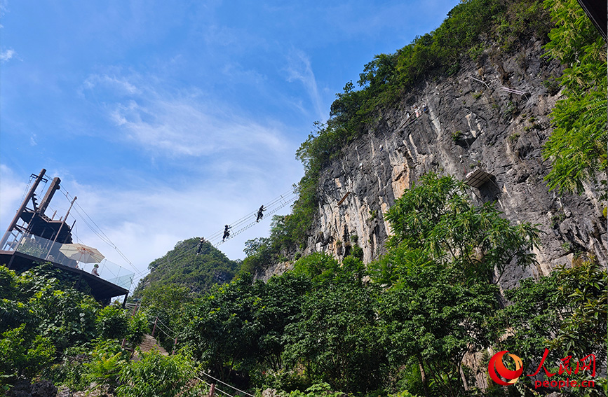 行進(jìn)中國(guó)丨穿梭云端峭壁 解鎖桂林山水新視角當(dāng)游客穿戴好安全設(shè)備，爬上通往懸崖峭壁的“天梯”，懸于山間，腳下是美麗的田園風(fēng)光，清澈的小河蜿蜒流淌，遠(yuǎn)處是連綿的山峰，共同構(gòu)成了一幅生機(jī)勃勃的山水田園畫(huà)卷。