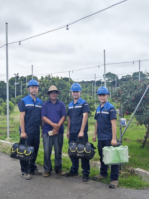 中國電信工程師在果園與果農(nóng)調(diào)試設(shè)備。李天興攝