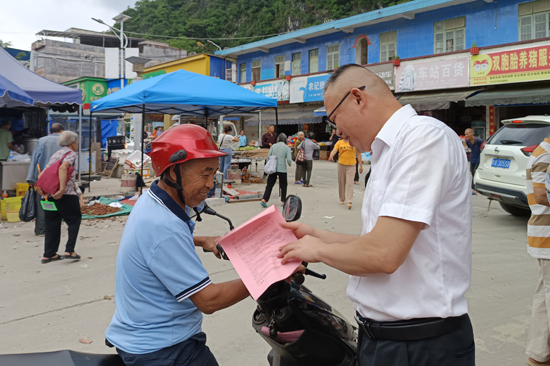 工作隊(duì)員為群眾發(fā)放并講解普法資料。黃柳民攝