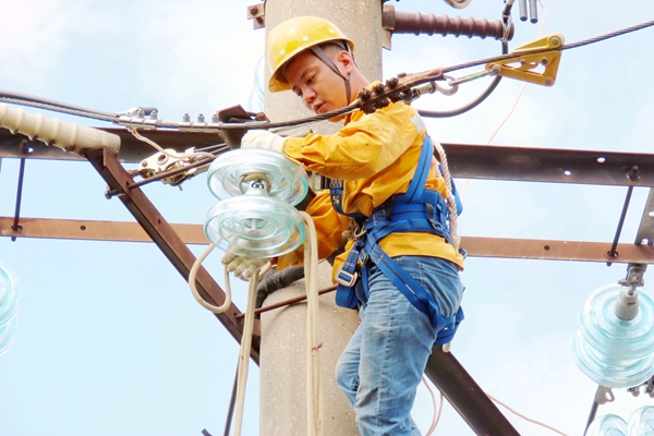 青年職工在安裝玻璃絕緣子。宋婷婷攝