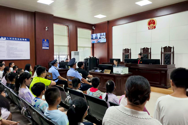 圖為家長(zhǎng)和孩子們旁聽(tīng)真實(shí)庭審。
