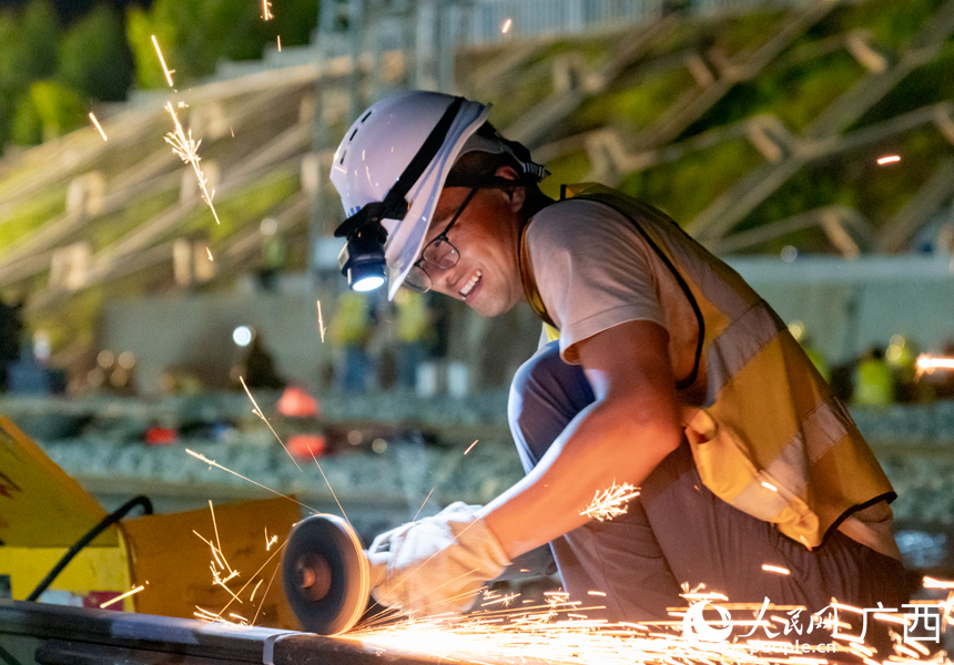 施工人員對鋼軌進(jìn)行打磨作業(yè)。