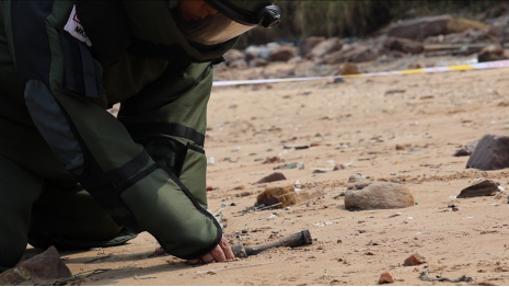 排爆手徒手撥開覆蓋在爆炸物表面的細(xì)沙。李聰攝