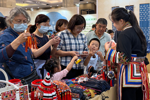 李素芳在向游客展示瑤繡。
