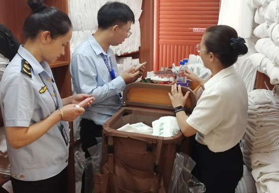 執(zhí)法人員和抽檢人員在賓館開展化妝品抽樣工作