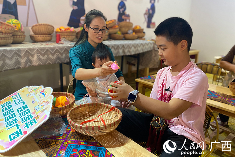 王秀芬教孩子們制作繡球。人民網(wǎng) 馮肖慧攝