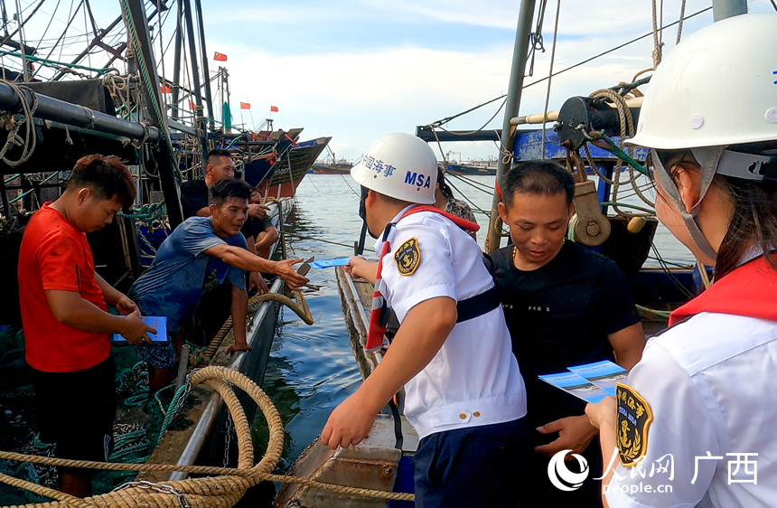 廣西海事部門開展“商漁共治”安全宣傳，向漁民發(fā)放宣傳冊。