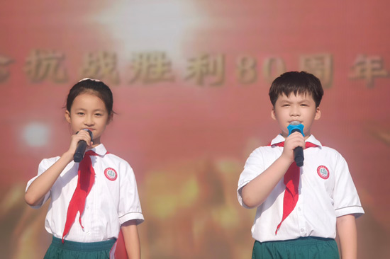 百色平果市第五小學少先隊員代表在國旗下朗誦和平宣言。共青團百色市委員會供圖