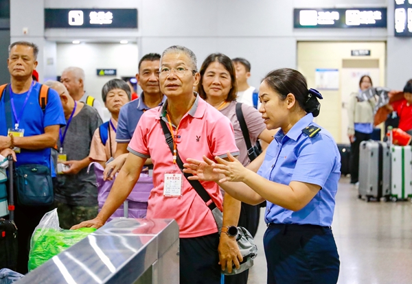 桂林北站工作人員向銀發(fā)旅客答疑解惑。鄭長(zhǎng)賢攝