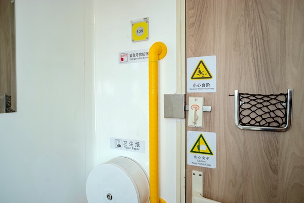 普惠型適老化旅游列車衛(wèi)生間內新增的緊急報警按鈕和L形扶手，還有加大加寬的提示標志。袁藝華攝