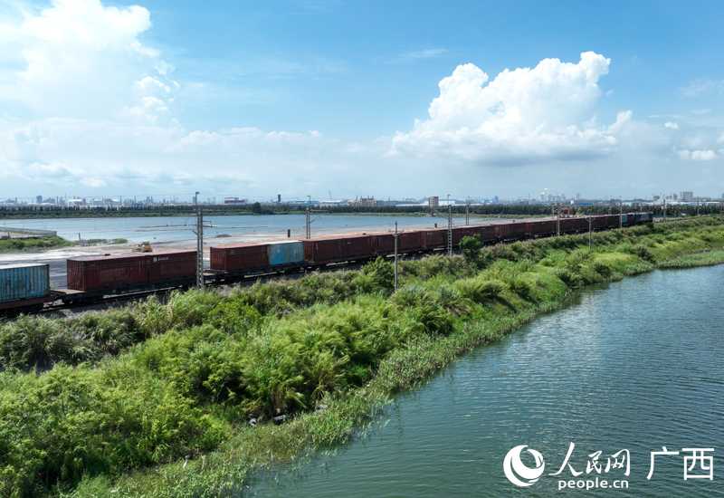 一趟滿載貨物的西部陸海新通道鐵海聯(lián)運班列，從廣西欽州港東站駛出。