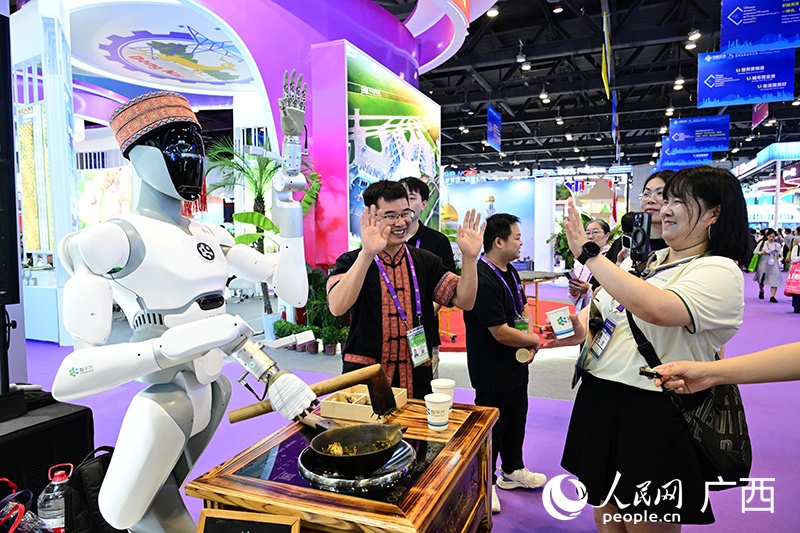 游客圍觀機器人打油茶。人民網 雷琦竣攝