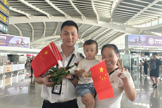 為旅客贈(zèng)送手持國(guó)旗和小禮品。王劍攝