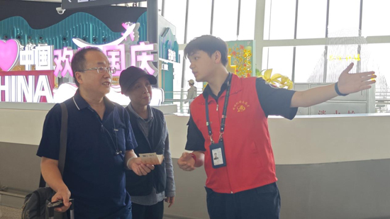 青年團(tuán)員志愿者引導(dǎo)旅客辦理登機(jī)手續(xù)。王劍攝