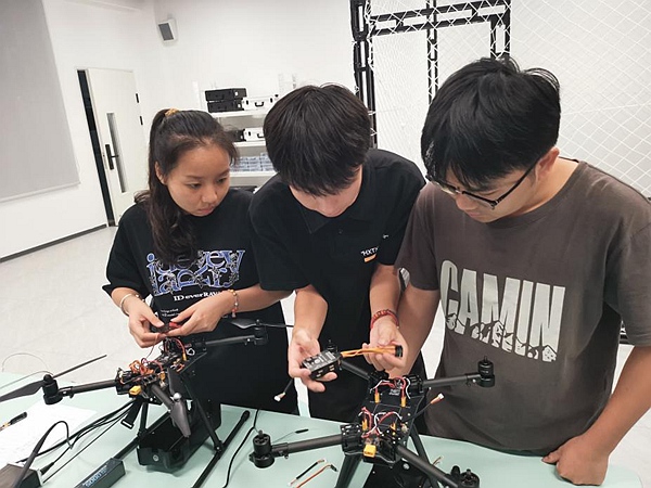 圖為馬山縣職校無(wú)人機(jī)教師指導(dǎo)學(xué)生裝配無(wú)人機(jī)