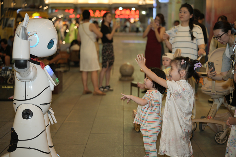 孩子們和機(jī)器人互動。