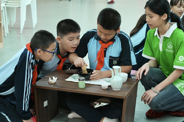 同學(xué)們手持茶筅攪動(dòng)茶碗，神情專注。馬金靜攝