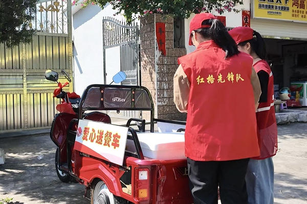 志愿者使用愛心送餐車為特殊困難家庭送餐。蘭茜攝