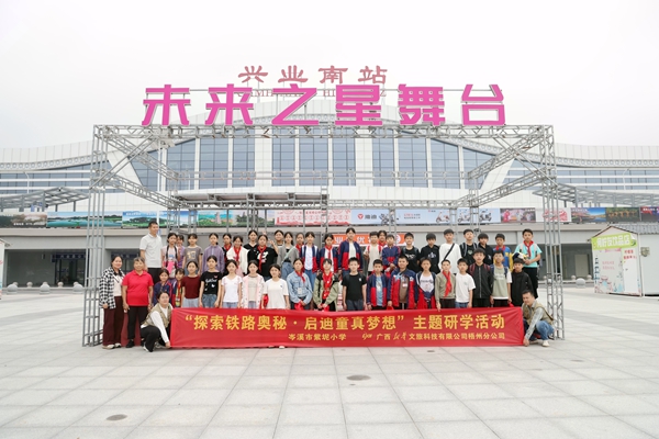 師生們在興業(yè)南站站前廣場合影留念。林鶴攝