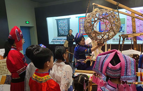 壯錦非遺傳承人向南寧市衡陽路小學(xué)師生介紹壯錦工藝