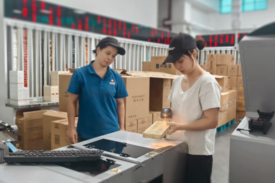 青年員工魯凱容(右)在分享異型煙快捷掃碼分揀技巧—陳美瑛攝