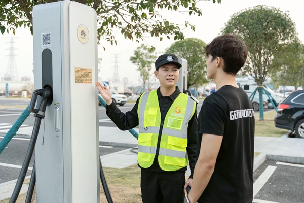 志愿者指導(dǎo)司乘人員使用充電樁設(shè)備。梁燕攝