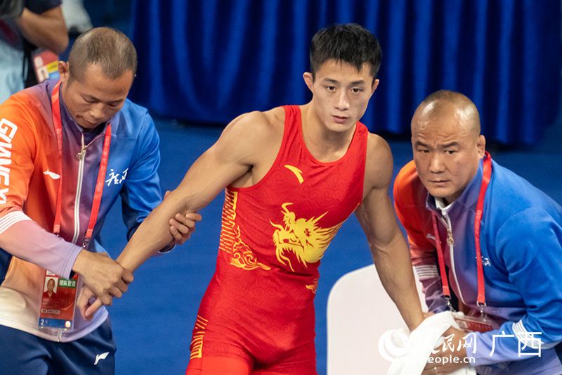 曹利國(guó)（中）與教練在中場(chǎng)休息片刻商量戰(zhàn)術(shù)。人民網(wǎng) 雷琦竣攝