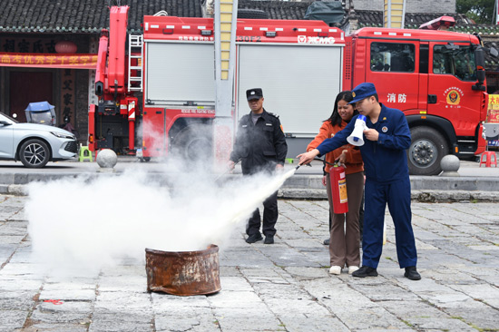 游客學(xué)習(xí)干粉滅火器的使用方法(馮韻詩 攝)