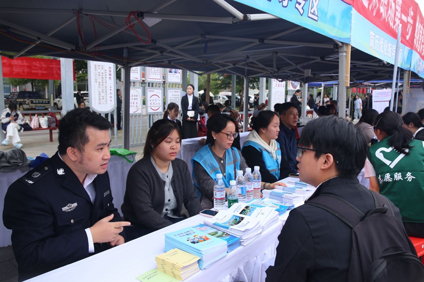 工作人員向畢業(yè)生宣傳相關(guān)就業(yè)政策。隆源攝