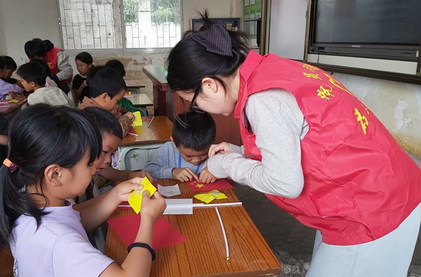 黨員志愿者與學(xué)生攜手制作國(guó)旗，厚植愛國(guó)情懷。廣西大錳集團(tuán)供圖