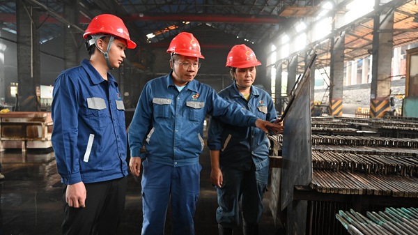 創(chuàng)新工作室錳業(yè)工匠蘭忠（居中）在車間協(xié)調(diào)生產(chǎn)。廣西大錳集團供圖