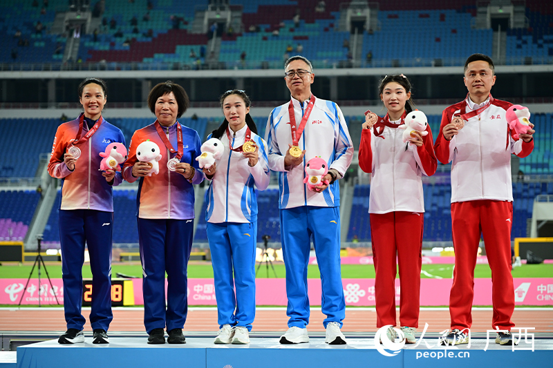 韋永麗（左一）與教練田玉梅（左二）登上領(lǐng)獎(jiǎng)臺(tái)。人民網(wǎng) 雷琦竣攝