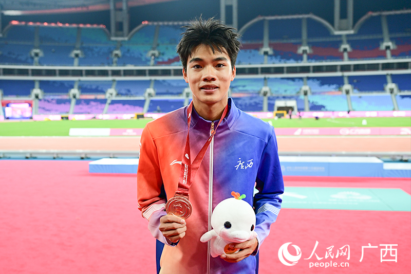 曾克理手持獎(jiǎng)牌和吉祥物。人民網(wǎng) 雷琦竣攝